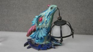 A metallic painted resin dragon head wall lamp with caged frosted glass globe shade. H.30 W.36cm