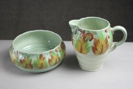 A large Clarice Cliff celadon glazed jug and bowl with foliate decoration. Makers mark on the