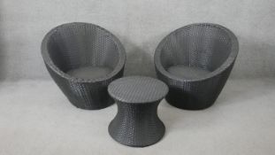 A pair of contemporary woven garden or conservatory tub seats and a matching low table.