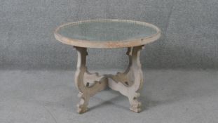 A Continental style painted occasional table with mirrored top on shaped cross stretchered supports.