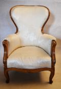 A 19th century carved walnut armchair in floral damask upholstery on cabriole supports. H.102 W.65