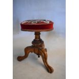 A Victorian carved walnut piano stool in original tapestry upholstery. H.42 W.30cm (Rise and fall