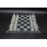 A contemporary glass chess set. To include thirty two pieces, 16 frosted glass pieces and 16 clear