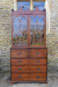 An early 19th century mahogany secretaire bookcase with scrolling arched pediment above astragal