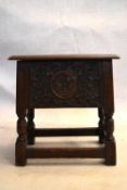 An 18th century country oak bible box stool with carved panel on turned tapering supports. H.47 W.44