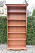 A 19th century style full height cherrywood open bookcase on shaped bracket feet. H.197 W.94 D.36cm