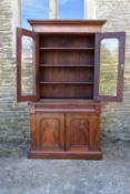 A Victorian mahogany library bookcase with upper glazed section above frieze drawer and panel