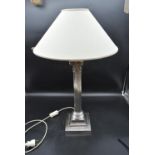 A 20th Century silver plated Corinthian column style table lamp with cream shade. H.58cm (H.68cm