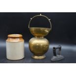 A late 18th century brass begging bowl, along with a two tone stoneware jar and a flat iron. H.40