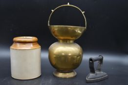 A late 18th century brass begging bowl, along with a two tone stoneware jar and a flat iron. H.40