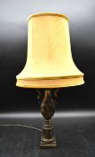 A brass baluster lamp with embossed Oriental male and female figural decoration and rope style