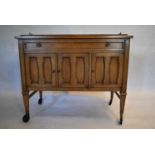 A walnut buffet cabinet with galleried top on square tapering supports terminating in wheel casters.