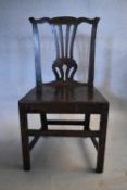 A Georgian oak hall chair with pierced vase shaped splat above panel seat on square stretchered