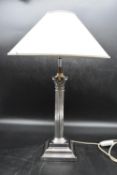 A 20th century silver plated Corinthian column style table lamp with cream shade. H.47cm (lamp) (