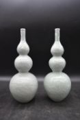 A pair of Chinese green celadon glaze dragon design triple gourd vases. Qianlong mark to the base.