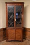 A large Georgian mahogany and satinwood inlaid corner cupboard with dentil moulded cornice above