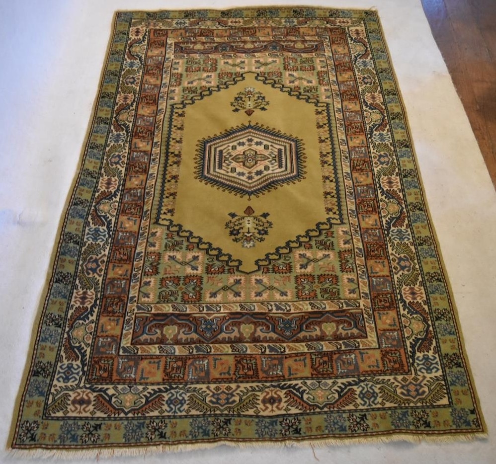 An Eastern rug with central hexagonal medallion in stylised multiple borders. L.234 W.134cm