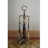 A contemporary wrought iron fire stand with four utensils with brass detail to the handles. To
