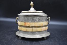 An Eastern pewter lidded caddy with ring handles either side, decorated with incised floral