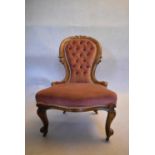 A Victorian carved walnut nursing chair in deep buttoned upholstery on cabriole supports. H.90 W.