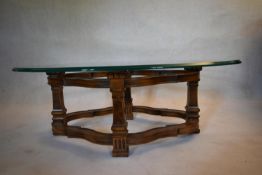 A contemporary antique style low table with heavy bevelled plate glass top on shaped stretchered