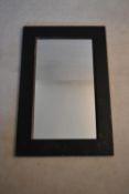 A contemporary wall mirror in ebonised teak frame. H.91 W.60cm