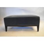 A contemporary upholstered footstool on lacquered ebonised supports. H.35 W.82 D.42cm
