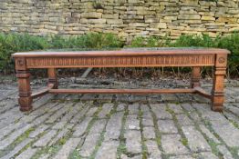 A carved fruitwood coffee table with inset plate glass panels on square stretchered supports. H.42