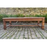 A carved fruitwood coffee table with inset plate glass panels on square stretchered supports. H.42