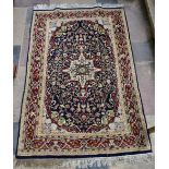 A Persian style rug with central pendant medallion on midnight ground contained by floral