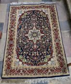 A Persian style rug with central pendant medallion on midnight ground contained by floral