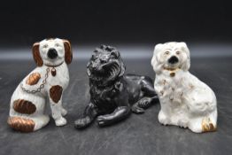 Two Staffordshire dogs and a black painted spelter lion. H.14 W.20cm