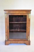 A Victorian figured walnut and ormolu mounted pier cabinet with Arabesque inlay and glazed panel