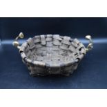 A contemporary wicker log or fruit basket with brass handles, designed by David Marshall. H.18 Dia.