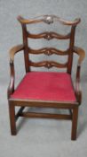 A Georgian style mahogany child's armchair with carved ladder back above drop in seat on square