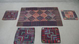 A Tibetan woven throw and four matching cushion covers. L.144 W.90 cm (largest)