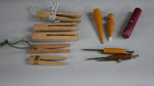 A collection of 19th century sewing items. Including wooden wool pegs, a fabric marker and other