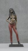 An erotic spelter figure of a topless woman in red skinny jeans. H.58 W.23 D.12cm