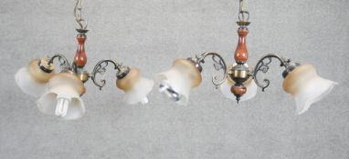 A pair of brass and wood effect three branch chandeliers with opaque fluted glass shades. Diam.50cm
