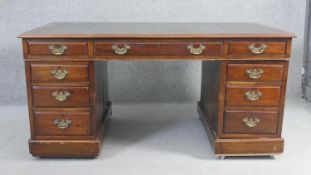 An early 20th century mahogany three section pedestal desk with gilt tooled leather inset top on