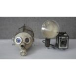 A vintage brownie camera with flash along with a steam punk gas mask sculpture. H.20 D.18cm