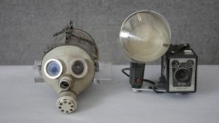 A vintage brownie camera with flash along with a steam punk gas mask sculpture. H.20 D.18cm