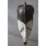 A carved and painted African DRC Gabon Fang Ngil hardwood mask. H.60 W.25cm.