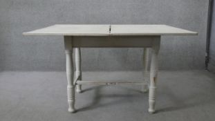 A 19th century painted pine fold over top dining table. H.80 W.100 D.66cm (not extended)