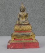 A 19th century Thai carved gilded and lacquered seated Buddha on stand with lotus petal