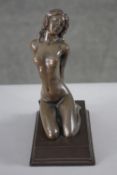 An erotic patinated spelter figure of a kneeling nude woman on rectangular base. H.20 W.15 D.8 cm.