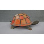 A vintage Tiffany style table lamp in the form of a tortoise with orange stained glass shade,