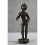 A 19th century Indian bronze figure of a deity on a circular base. H.22 W.8cm