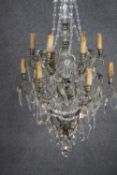 A vintage cut crystal and brass twelve branch chandelier with crystal swags and faceted ball to