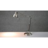 A brushed chrome anglepoise style adjustable desk lamp on circular base. H.34 W.36cm